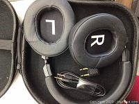 Srhythm black noise cancellation earphones with cushioned L and R ear pads, laid in black carrying case with included cable and adapter