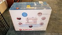 Photo of the sealed Singer Tradition 2259 sewing machine box showing the product image and features on the front side.