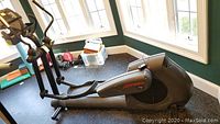 Left side overall view of black/grey elliptical machine in room