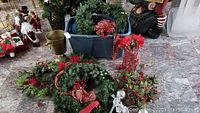 Photo showing brass planter holder, multiple artificial Christmas wreaths decorated with red poinsettias and holiday bows, and a pair of glitter wired decorative shoes.