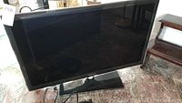 Samsung 40in flat screen TV in black with stand, front view.