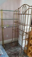 Brass glass shelf with three glass tiers, metal frame visible with wear and oxidation