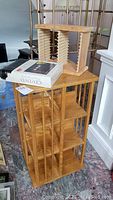Wooden swivel CD/DVD rack with multiple vertical slots, timeline approximately 33 inches tall, 18x18 base.