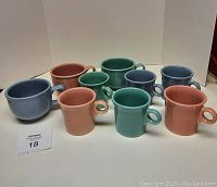 Image showing all nine mugs including three larger soup mugs and six smaller coffee mugs in pastel colors arranged in two rows.