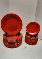 Eleven 10-inch dinner plates stacked on left and twelve 7-inch dessert plates stacked on right against plain background