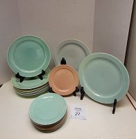 First image showing a stack of nine 6-inch LuRay plates in turquoise and peach colors with some 9-inch plates displayed upright.