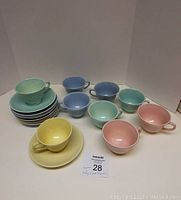 Full set of 9 LuRay pastel cups and saucers stacked and grouped, showing all colors and pieces.