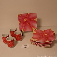 Full view of the 6 square plates stacked next to 4 coffee mugs in a set with a number card