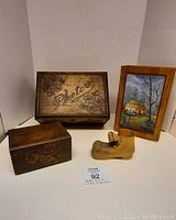 Two wooden boxes with wood burnt floral designs, one labeled 'Photos', and the carved wooden shoe with the vintage painted box behind them.