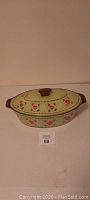 Temptations green floral 3.5 quart oval covered casserole dish with lid on top, showing floral exterior pattern and brown handles.