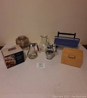 Full lot showing all miscellaneous kitchen items on table against wall