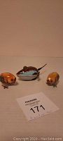 Two tin bobbing chicks and one tin wind-up mouse shown together on a flat surface with a lot number tag.