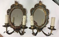 Pair of vintage Florentine wall sconces with mirrors and two candle holders each, showing aged patina and wear.