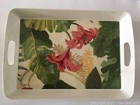 Full view of the rectangular white ceramic serving tray with tropical floral pattern and integrated handle cutouts on each end.