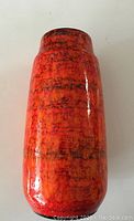 Full front view of the vintage West German ceramic vase showing the orange and red mottled glaze with black accents.