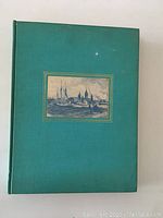 Front cover of the green hardcover book showing framed illustration of ships and city skyline.
