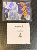 Photo showing Kobe Bryant SPx hologram refractor card with Lakers purple and gold colors and branding.