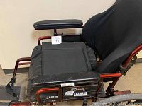 Side view of the Maple Leaf Super Tilt wheelchair showing padded black seat, backrest, armrests, and footrests with straps.