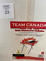 Photo of packaging showing Team Canada Snack Tray Table branding and image of table with maple leaf design and folding legs.
