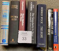 Front cover and spine view of 7 hardcover books showing titles and authors