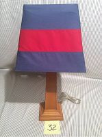Front view of Pottery Barn Kids table lamp showing wooden base and blue-red striped fabric shade