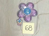 Large and small flower shaped doorbell components placed on striped fabric background with lot label 68