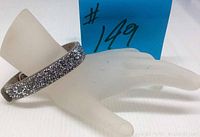 Gray faux leather wristband bracelet covered with small crystals and featuring two sized crystal buttons as closure, displayed on a hand mannequin with lot number tag visible.