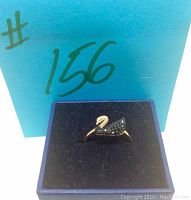 Front view of Swarovski rose gold plated swan ring with black crystals in display box with #156 handwritten on box.