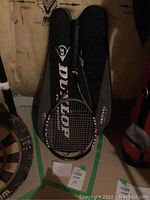 Two black Dunlop 200G tennis rackets resting on their zippered carrying cases with visible Dunlop branding.