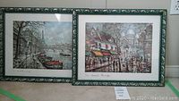 Two framed Paris prints with green ornate frames displayed side by side.
