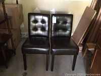 Two dark brown pleather highback chairs side by side showing overall condition and shape