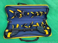Full open carry case with all clamps inside, showing large bar clamp and spring clamps secured by velcro straps.