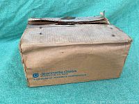 Vintage full case factory box for Jeannette Glass milk glass coffee mugs showing branding and condition.