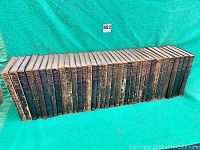 30 volume leather bound set of 1911 Encyclopedia Britannica arranged side by side, showing worn and scuffed black covers.