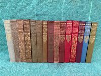 Upright front view of 16 cloth-bound Everyman’s Library volumes in grey, brown, olive, maroon, red, blue and green