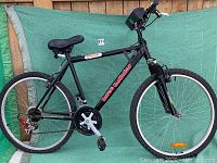 Side view of the black Raleigh Intense Coillux mountain bike showing the full frame, tires, seat, and mounted accessories on handlebar.