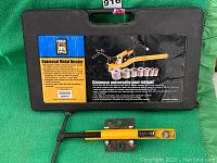 Black plastic carrying case with label showing the product name PowerFist Universal Metal Bender and details about the product features.