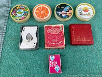 Lot of vintage playing cards including four souvenir round card sets and various other decks.