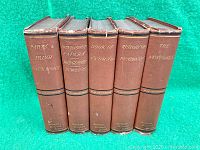 Front view of six hardcover books showing spines with titles and author's name.