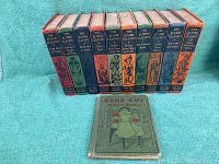 Front view of 11 Junior Classics children's books and one Child Life Reader A book laid out on a turquoise fabric surface.