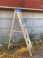 Step ladder standing open with blue top and aluminum frame