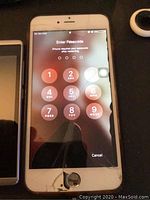 Front side of iPhone 6s showing cracked screen and passcode entry.