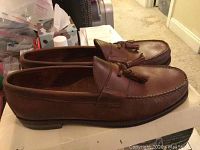 Side profile view of the brown leather men's dress loafers showing the tassels and stitching detail