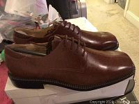 Side angled view of the brown leather dress shoes, showing the profile and heel.
