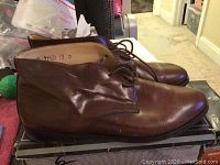 Side view of Giorgio Brutini brown leather men's dress shoes size 13 on top of box.
