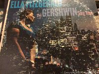 Cover of the Ella Fitzgerald 'The Gershwin Song Book' vinyl LP showing the singer against a city skyline background.