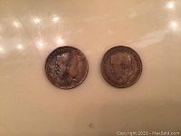 Obverse side showing two King George V large pennies with visible age patina and inscriptions.