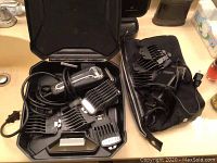 Two Wahl hair clippers with comb attachments, cords, and cases on a bathroom counter.