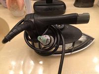 Silver Star gravity feed steam iron coiled black cord, metal soleplate, black handle with chipped end.