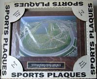 Photo showing framed sports plaque with aerial view of the Daytona International Speedway track and surrounding area, inside labeled packaging.